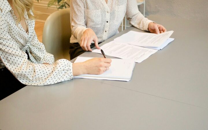 Personas firmando documentos jurídicos empresariales