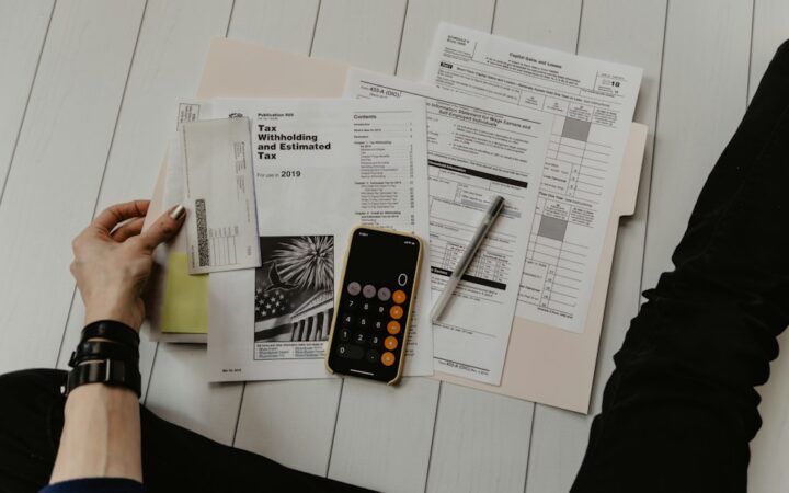 Persona revisando documentos fiscales con calculadora y bolígrafo