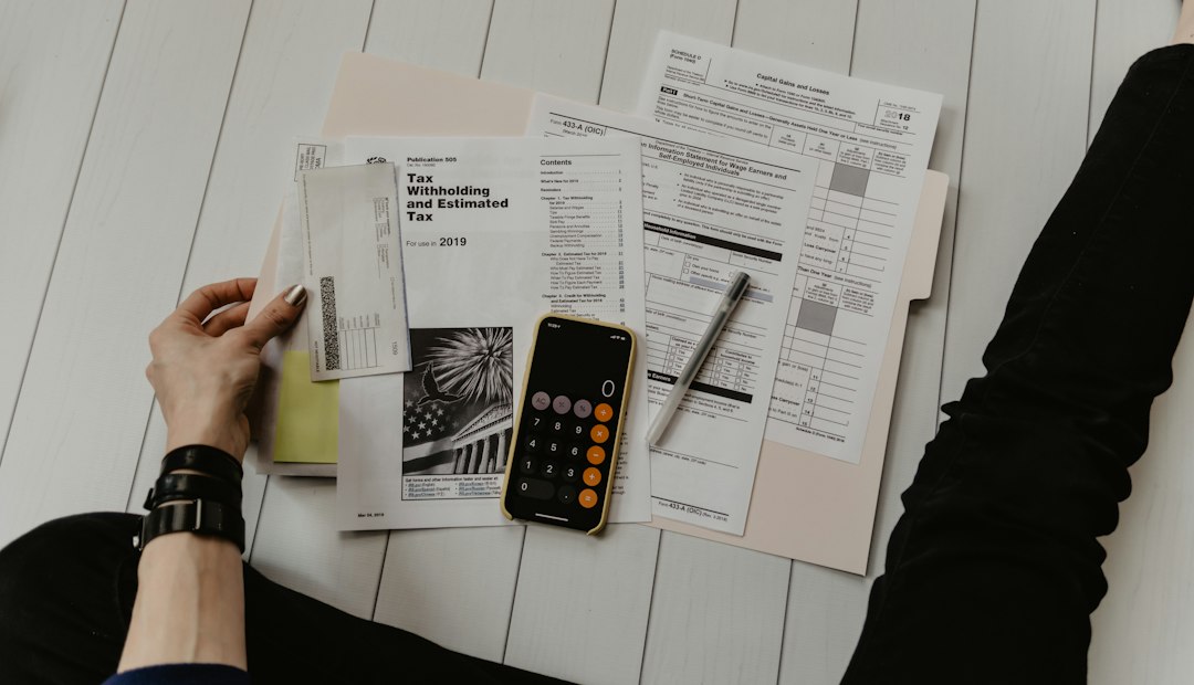 Persona revisando documentos fiscales con calculadora y bolígrafo
