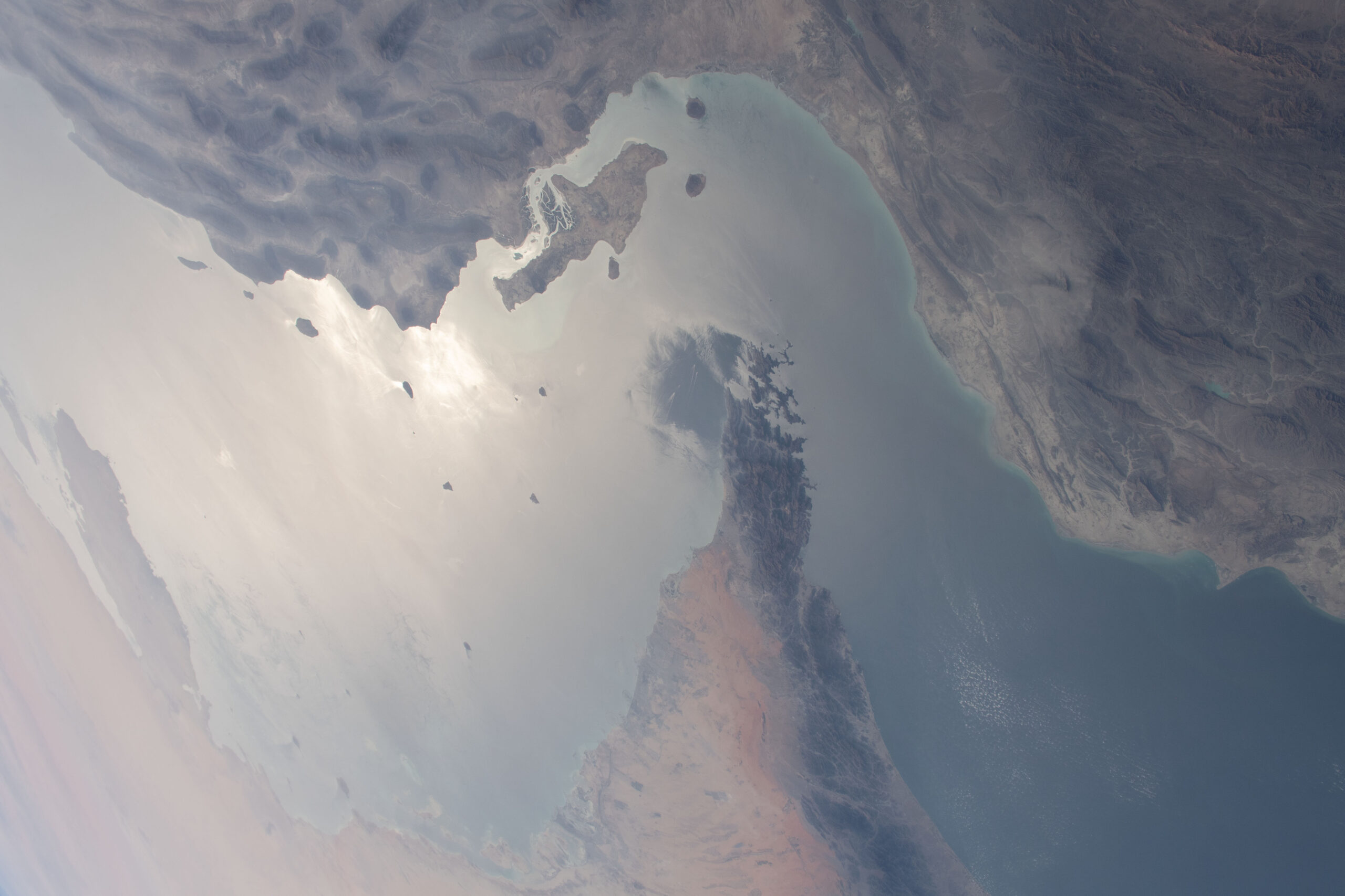 Vista aérea del estrecho de Ormuz entre Irán y la península de Musandam, tomada desde la Estación Espacial Internacional en marzo de 2021. Imagen de archivo de NASA; no muestra los ataques de 2026.