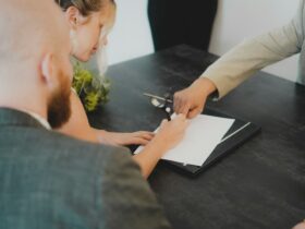 Personas firmando la documentación de una compraventa inmobiliaria