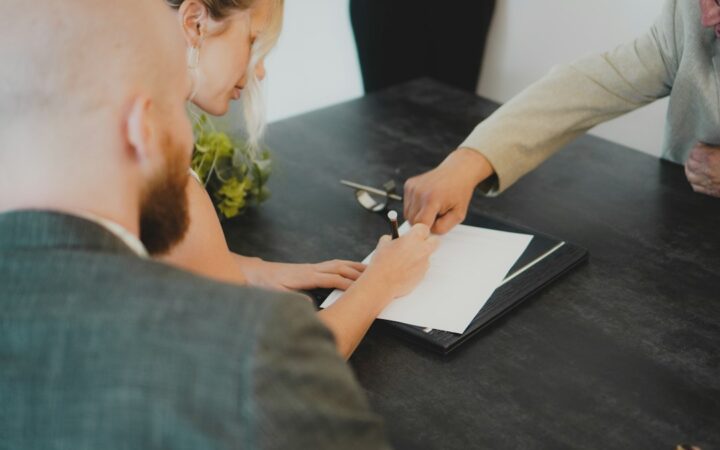 Personas firmando la documentación de una compraventa inmobiliaria