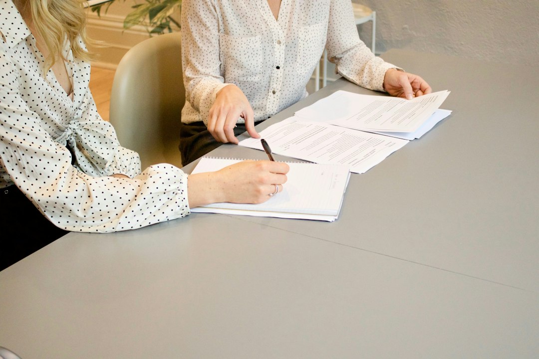 Dos profesionales revisan y firman documentación empresarial