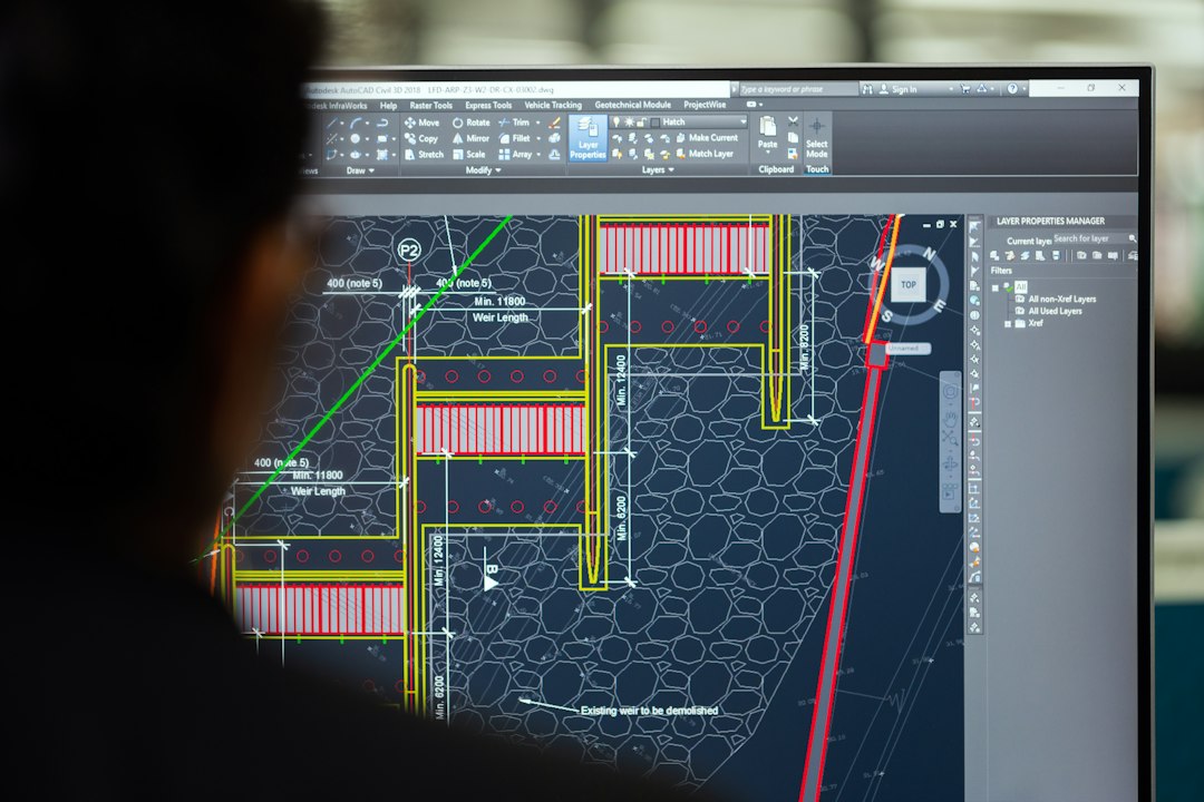 Ingeniera trabajando con planos técnicos y herramientas digitales