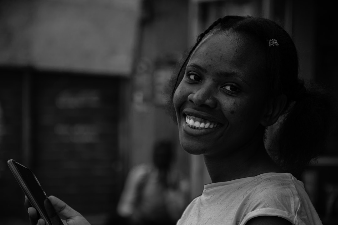 Mujer africana utilizando un teléfono móvil para servicios financieros