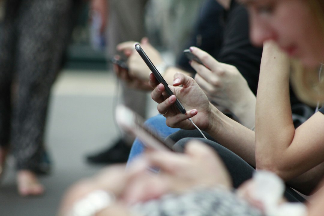 Personas utilizando teléfonos móviles en un contexto de regulación de redes sociales