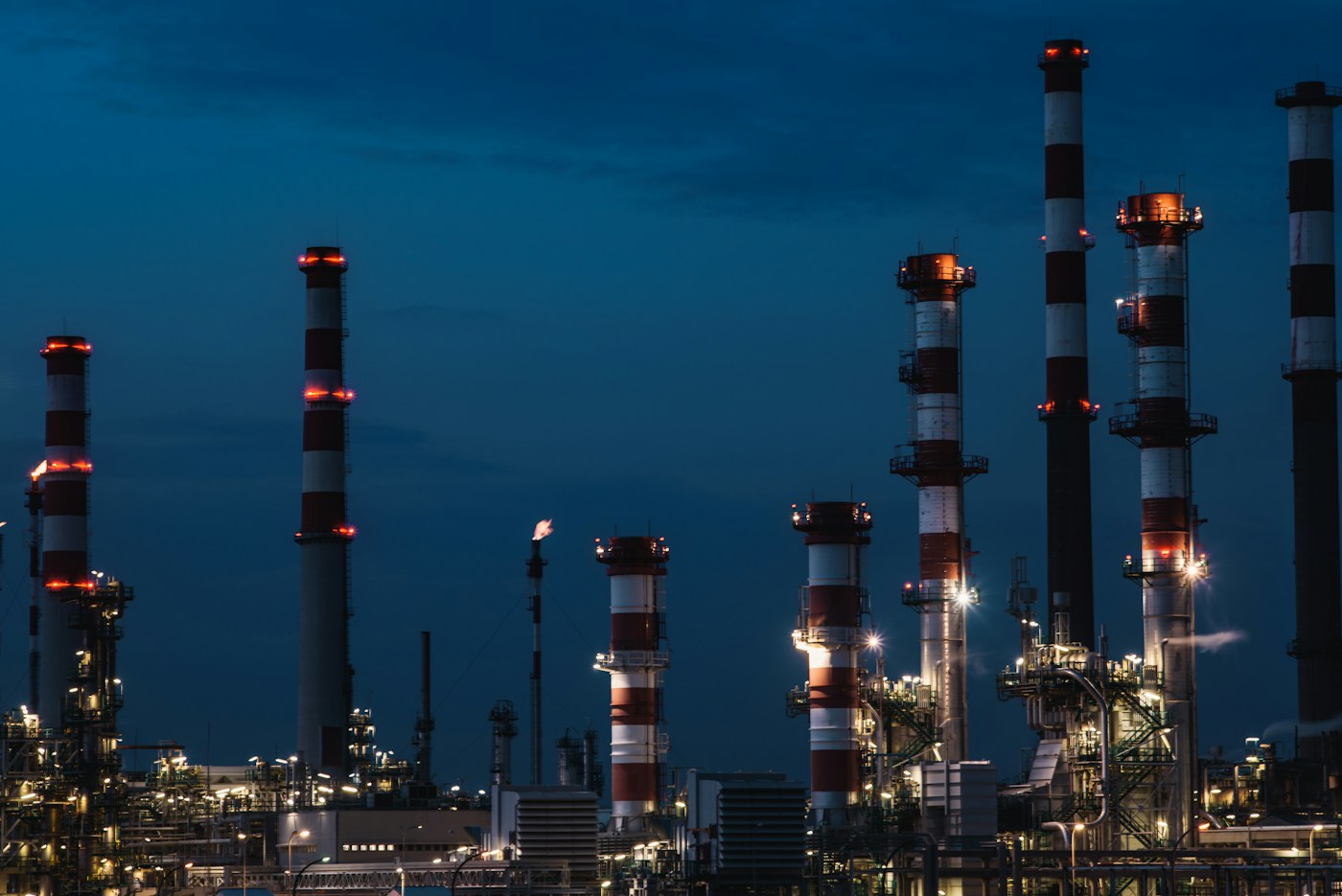 Refinería de petróleo iluminada al anochecer