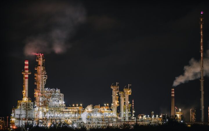 Refinería de petróleo iluminada al anochecer