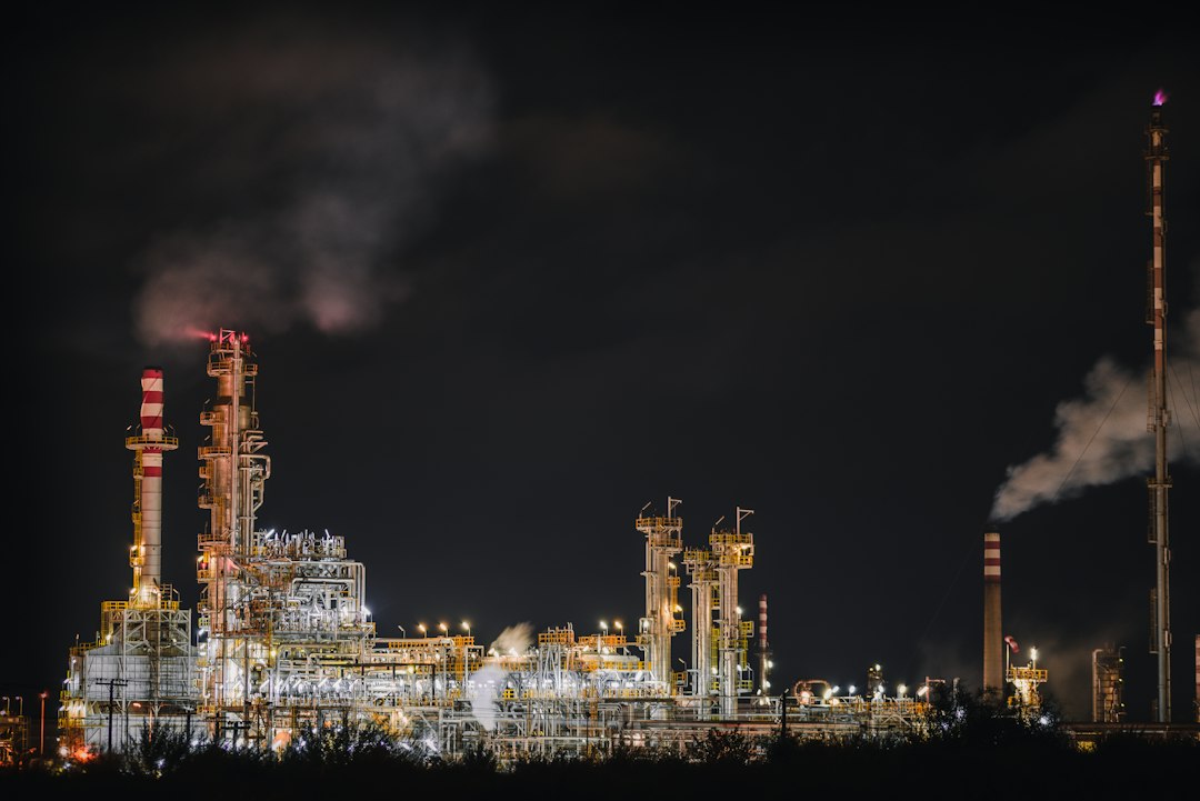 Refinería de petróleo iluminada al anochecer