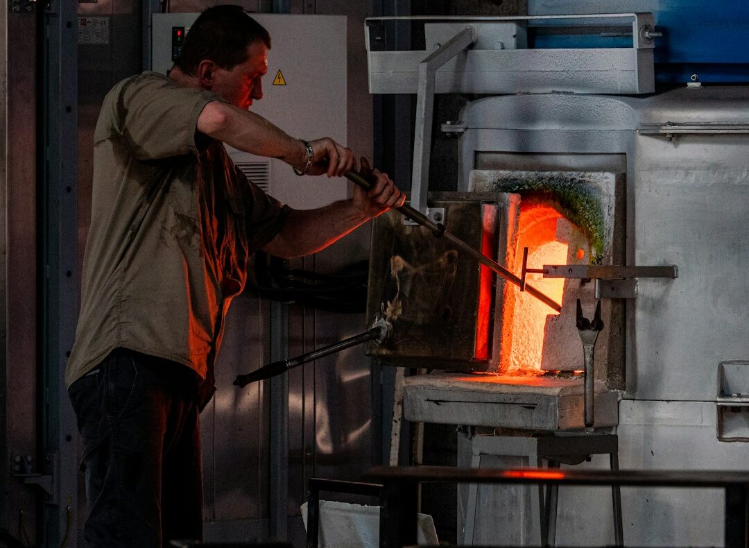 Vidriero trabajando frente a un horno industrial