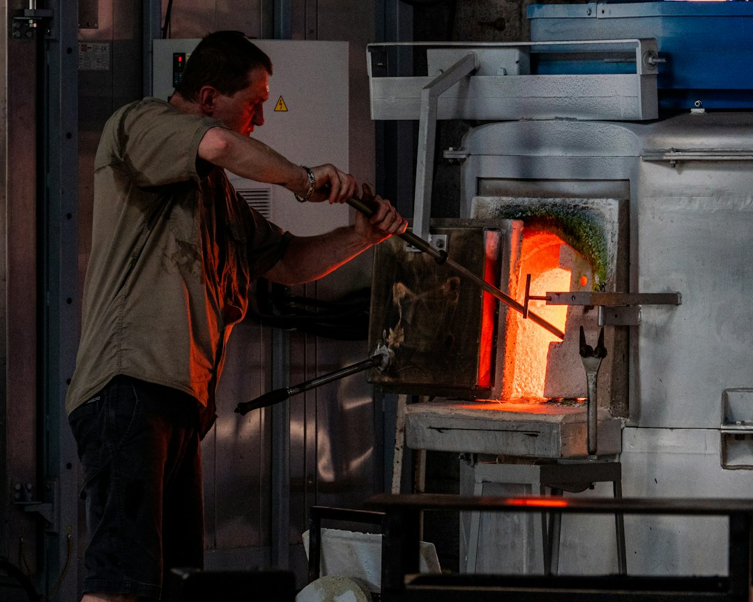 Vidriero trabajando frente a un horno industrial