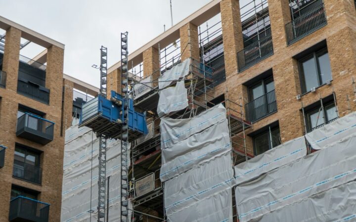 Fachada de un edificio en construcción con paneles y andamios