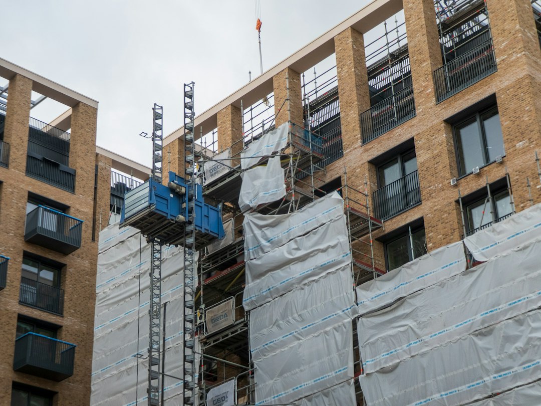 Fachada de un edificio en construcción con paneles y andamios