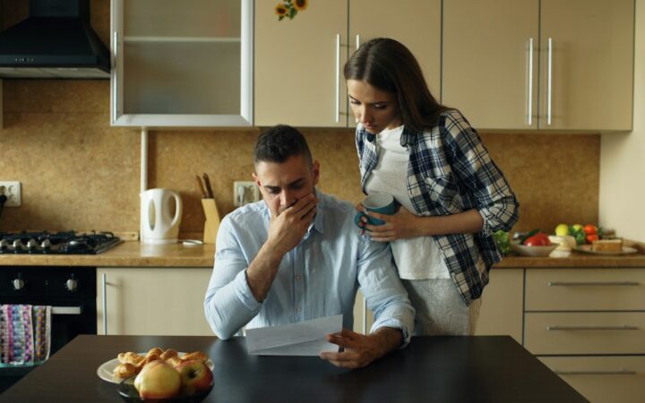 Pareja revisando facturas y deudas domésticas